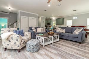 a living room with two couches and a table at Blue Haven - 1414 Oleander in Dauphin Island +40 photos