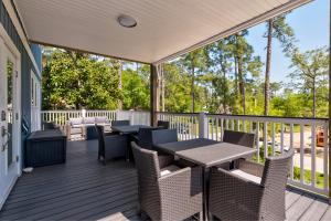 a patio with tables and chairs on a deck at Blue Haven - 1414 Oleander in Dauphin Island