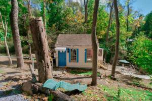 a small house with a blue door in the woods at Vintage Lovers` Cabin with Jacuzzi & Lake Access in Linden