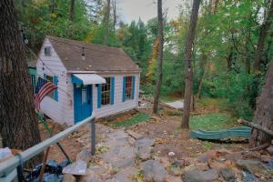 a tiny house in the woods with an american flag at Vintage Lovers` Cabin with Jacuzzi & Lake Access in Linden