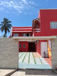 a red house with a red garage at Suítes Concha do Sol in Maragogi