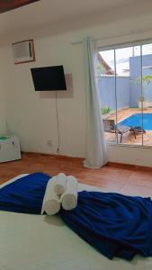 a bedroom with a bed with two towels on it at Pousada Litorânea in Saquarema