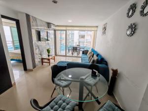 a living room with a glass table and chairs at ARENA PLAZA DEPARTAMENTO PLAYA con vista al mar in Tonsupa
