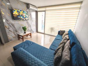 a living room with a blue couch in front of a window at ARENA PLAZA DEPARTAMENTO PLAYA con vista al mar in Tonsupa