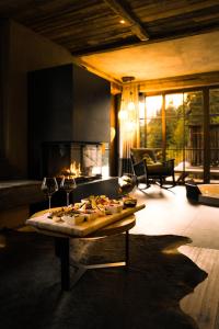 a living room with a table with food and a fireplace at Mons Silva Private Luxury Chalets in Racines