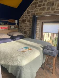 a bedroom with a bed and a stone wall at Gîtes d Izel2 entre terre et mer prés d'un golf in Ploemel +119 photos