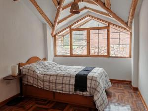 a bedroom with a bed and a large window at UMAY lodge house in Urubamba