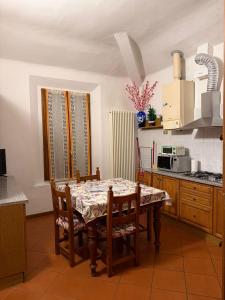 a kitchen with a table and chairs and a kitchen with a microwave at Molinella Appartamento Amelia & Carlo in Molinella