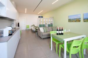 a kitchen and a living room with a table with wine bottles on it at Al Ventisei - Verde in Treiso +12 photos