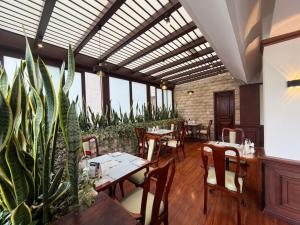 ein Restaurant mit Tischen, Stühlen und Pflanzen in der Unterkunft Hotel Republica in Quito