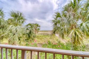 a view of the beach from a balcony with palm trees at Holiday Isle 122 in Dauphin Island