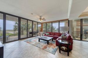 a living room with a red couch and glass windows at Holiday Isle 122 in Dauphin Island