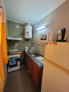 a small kitchen with a refrigerator and a sink at Balcones de Bialet in Bialet Massé