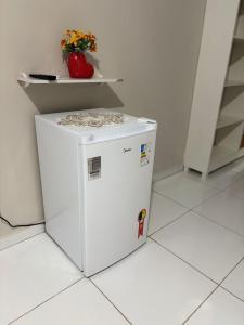 a small white refrigerator sitting on a white floor at Chalé da Ana in Tutóia