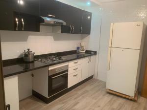 a kitchen with white appliances and a white refrigerator at Studio dream place in Kenitra