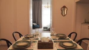 a dining room table with plates and wine glasses at Weiss Central Boutique in Braşov