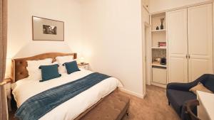 a bedroom with a bed and a blue chair at Weiss Central Boutique in Braşov +31 photos