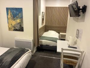 a hotel room with two beds and a tv at Villa Hotel in Troyes