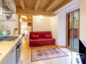 a living room with a red couch in a kitchen at Apartment Casa del Bitto by Interhome in Pedesina +41 photos