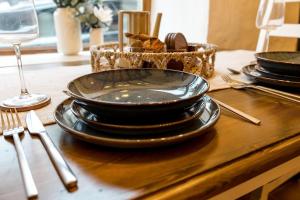 a table with black plates and utensils on a table at Hoot Cottage in Oakworth