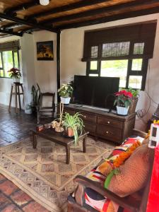 a living room with a couch and a tv at La cabaña de la abuela in Sutatausa