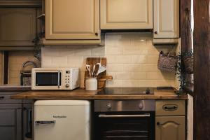 a kitchen with a counter top with a microwave at Hoot Cottage in Oakworth