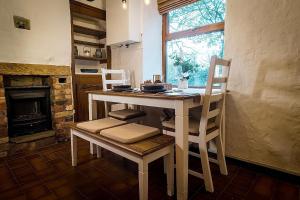 a kitchen with a table and chairs and a fireplace at Hoot Cottage in Oakworth
