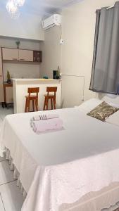 a bedroom with a large white bed with two chairs at Chalé da Ana in Tutóia