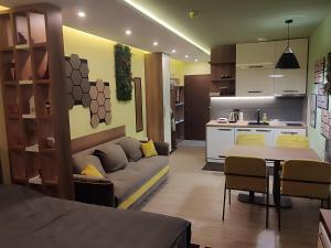 a living room with a couch and a kitchen at Yellow Hill Apartment in Cajetina