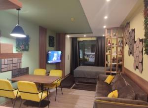 a living room with a couch and a table and a bed at Yellow Hill Apartment in Cajetina
