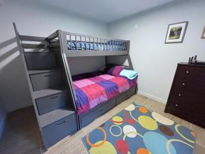 a small bedroom with a bunk bed and a ladder at Coastal Drift Sooke in Sooke
