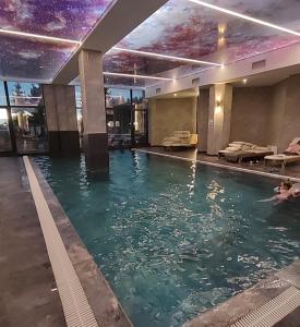 a person swimming in a swimming pool at Yellow Hill Apartment in Cajetina