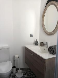 a bathroom with a toilet and a sink and a mirror at Casinha da Aurora in Pedorido