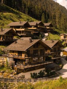 a group of wooden buildings on a mountain at Mons Silva Private Luxury Chalets in Racines