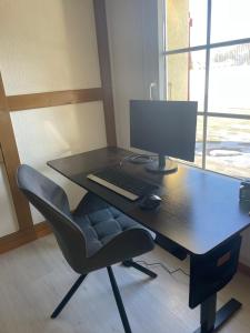 a desk with a computer monitor and a chair at Studio with Kitchen & Parking near Thun and Bern in Herbligen 