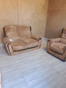 a couch and a chair in a room at Rest Easy in Grasmere