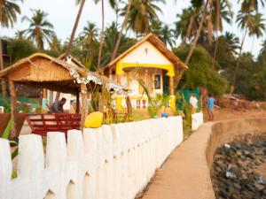 a white fence in front of a house at La Rocha in Patnem