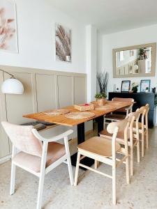 a dining room with a wooden table and chairs at Limon Home in Benacazón