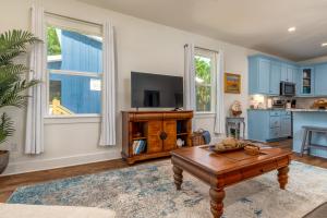 a living room with a tv and a coffee table at Lavender Haze - 1209 Chaumont in Dauphin Island