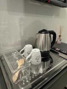 a coffee pot and two cups on a stove at Luxury Rooms Soraja in Palermo +17 photos
