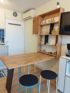 a kitchen with a wooden table and two stools at La Terrasse des Voiliers in Frontignan +9 photos