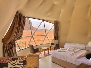 a bedroom with two beds and a large window at WADl RUM DESERT CAMP in Wadi Rum +198 photos