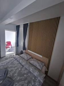a bedroom with a bed and a window with a chair at Casa DARYA-24h Check-in in Bucharest