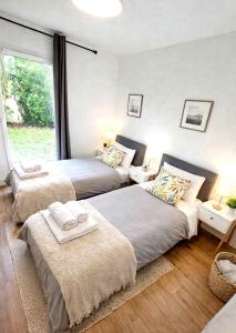 a bedroom with two beds and a window at Le Cottage Jardin élégant & cosy, plage pour 6 personnes, animaux admis Biscarrosse in Biscarrosse