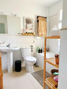 a bathroom with a toilet and a sink at Limon Home in Benacazón +29 photos