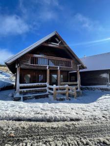 a log cabin in the snow with a fence at Chalet O Refúgio 1 in Penhas da Saúde