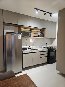 a kitchen with a stainless steel refrigerator and appliances at Apartamento Ipioca Beach Life in Ipioca