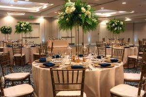 a banquet hall with tables and chairs with white flowers at Fort Lauderdale Marriott Pompano Beach Resort in Pompano Beach +127 photos