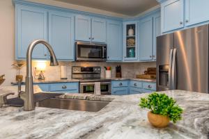 a kitchen with blue cabinets and a marble counter top at Lavender Haze - 1209 Chaumont in Dauphin Island