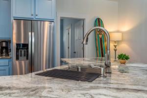 a kitchen with a sink and a counter top at Lavender Haze - 1209 Chaumont in Dauphin Island +17 photos